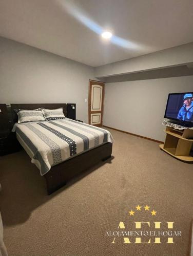 a bedroom with a bed and a flat screen tv at El Hogar - Sucursal Calle Julio Mendez y Obispo Anaya con Garaje cubierta in Cochabamba