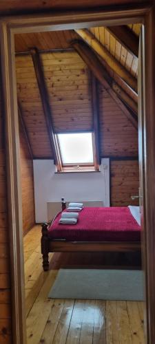 a bedroom with a red bed in a attic at Kraljevi Konaci Olja in Zlatibor