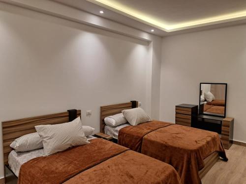 a hotel room with two beds and a mirror at New Cairo Cozy Studio استديو فندقى بالتجمع in New cairo