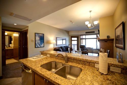 a kitchen with a sink and a living room at Ski IN Out, Perfect Location King Bed at Sundial Lodge w Hot Tub and Pool! in Park City