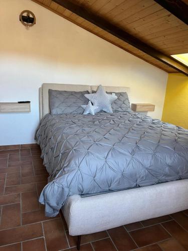 a bedroom with a bed with a gray comforter at Il Cottage in Castel di Sangro