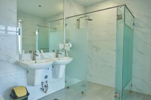 a bathroom with two sinks and a glass shower at Treewoods Residences in Cebu City