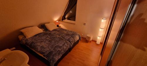 a small bedroom with a bed and a window at Lake house 21 relax accommodation iR Sauna in Warmond