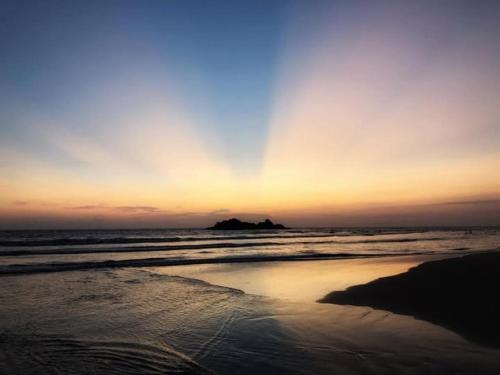 a sunset on the beach with the ocean at Sagarika Beach Hotel in Moragalla