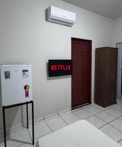 ein WC mit einem roten Ausstiegschild und einem Kühlschrank in der Unterkunft Hotel Leblon - SmarTV e Ar-Condicionado por Menos de 130,00 in Uberaba