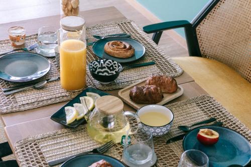 a table topped with plates of food and orange juice at Residence Saletta Mare in LʼÎle-Rousse