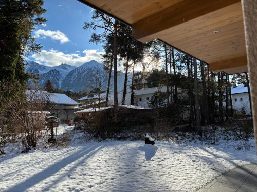 a snow covered yard with mountains in the background at Residenz Bergzauber in Ötztal-Bahnhof