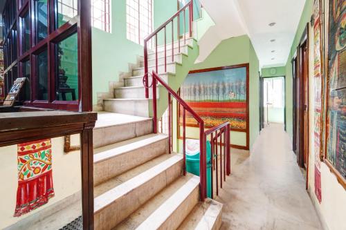 a staircase in a building with a painting on the wall at Hotel O Rainbow Stays in Tiruchchirāppalli