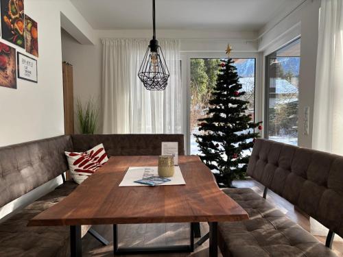 a living room with a table and a christmas tree at Residenz Bergzauber in Ötztal-Bahnhof