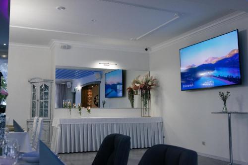 a white room with a tv on the wall at Hotel Wiktor in Świdwin