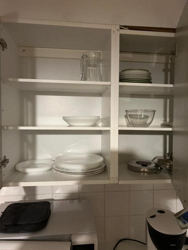 a white cabinet with plates and dishes on it at Mökki Leskelä Taivalkoski in Taivalkoski