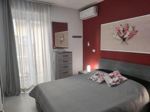 a bedroom with a bed and a red wall at Casa Orchidea Mazzeo in Mazzeo