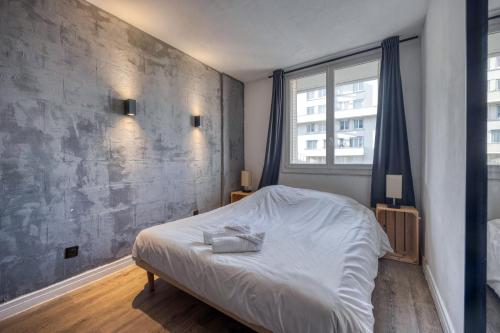 une chambre avec un lit blanc et une grande fenêtre dans l'établissement #HN Le Beauvert 4 people, à Grenoble