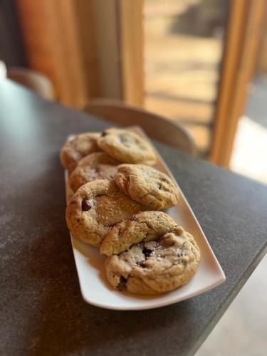 three chocolate chip cookies on a plate on a table at Chalet LE VAL NESS in La Côte dʼArbroz