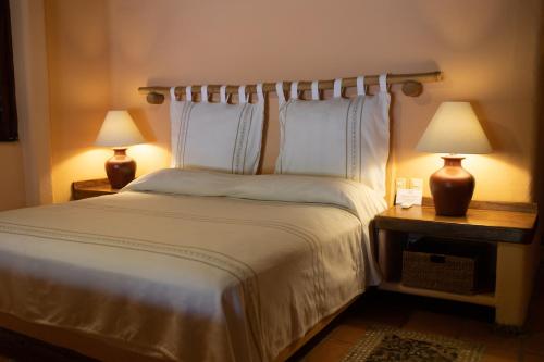 a bedroom with a large bed with two lamps at Puertas Paraíso Hotel boutique in Zihuatanejo
