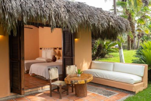 a bedroom with a bed and a couch and a table at Puertas Paraíso Hotel boutique in Zihuatanejo