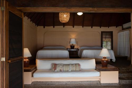 a bedroom with two beds and a couch with two beds at Puertas Paraíso Hotel boutique in Zihuatanejo