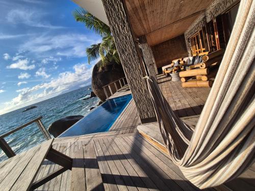 a house on the beach with a balcony and the ocean at Marquise & Infinity villas in Glacis