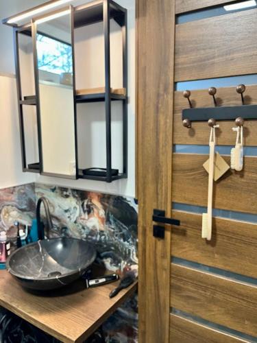 a bathroom with a sink and a wooden door at Domek Prosetin244 in Prosetín
