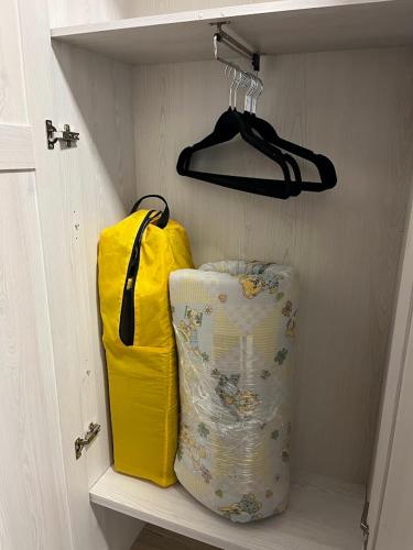 a closet with two yellow bags on a shelf at Domek Prosetin244 in Prosetín