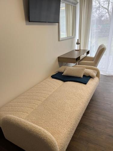 a bed in a room with a table and a chair at Domek Prosetin244 in Prosetín
