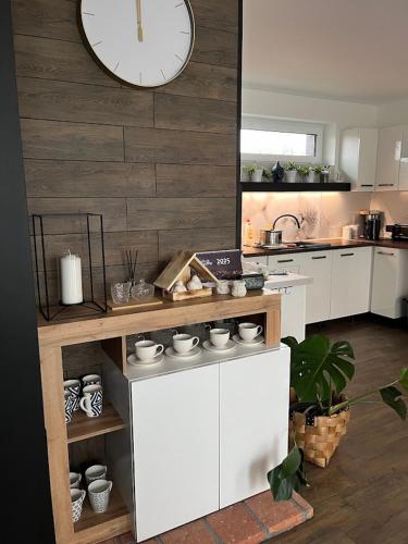 a kitchen with white cabinets and a clock on the wall at Domek Prosetin244 in Prosetín