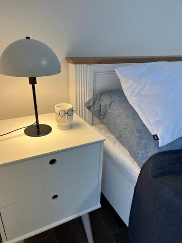 a bedroom with a bed with a lamp and a nightstand at Domek Prosetin244 in Prosetín