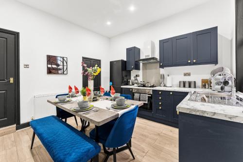 a kitchen with a table and blue chairs at Designer 4 Bed House in Leeds - Sleeps 13 in Leeds