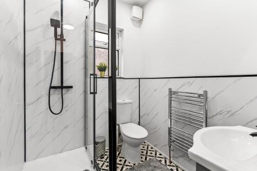 a bathroom with a shower and a toilet and a sink at Designer 4 Bed House in Leeds - Sleeps 13 in Leeds
