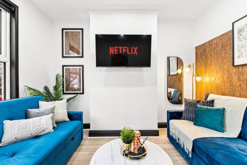 a living room with blue couches and a tv at Designer 4 Bed House in Leeds - Sleeps 13 in Leeds