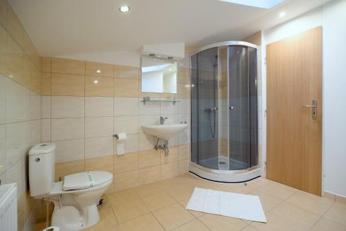 a bathroom with a toilet and a sink and a shower at Apartmány Hillfort in Bojnice