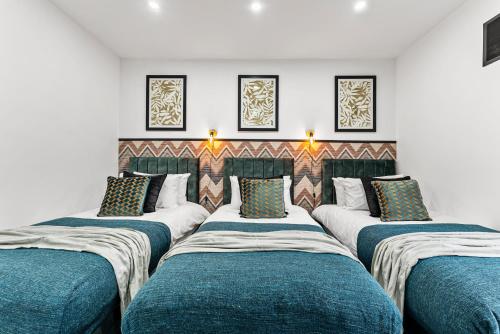 a group of four beds in a room at Designer 4 Bed House in Leeds - Sleeps 13 in Leeds