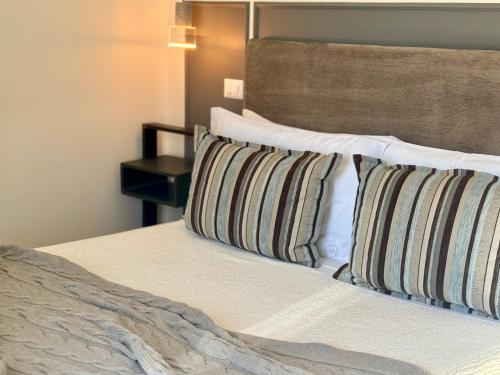 a bedroom with a bed with two pillows on it at HABITARE Lecce & Salento in Lecce