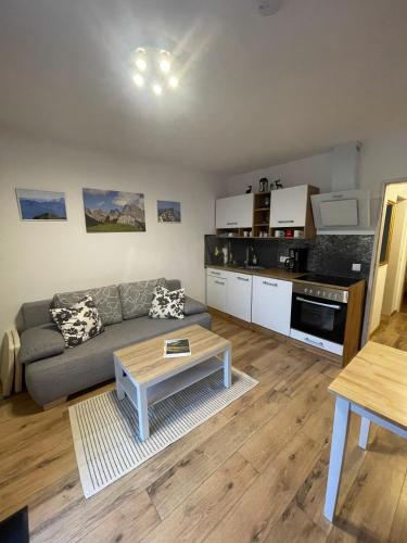 a living room with a couch and a table at Ferienwohnung Mittendrin - Chiemgau Karte in Inzell
