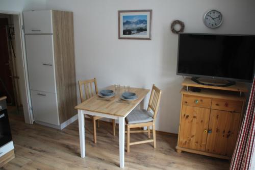 a small dining room with a table and a tv at Ferienwohnung Mittendrin - Chiemgau Karte in Inzell