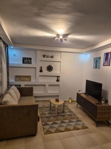 a living room with a couch and a tv at L'ancienne menuiserie in Tabarka