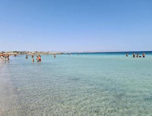 a group of people in the water at the beach at Casa Orchidea Mazzeo in Mazzeo