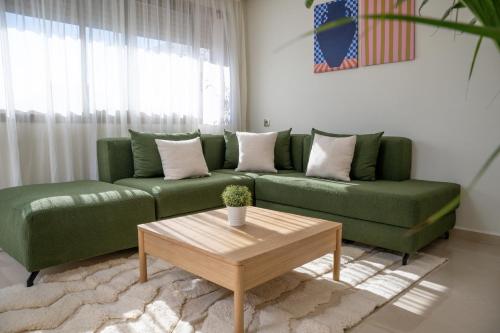a living room with a green couch and a coffee table at Charming Cozy apartments with terrace, Haut Agdal in Rabat