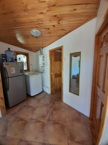 a kitchen with a wooden ceiling and a refrigerator at Casa los Misticos, Vicuña, Valle del Elqui in Vicuña