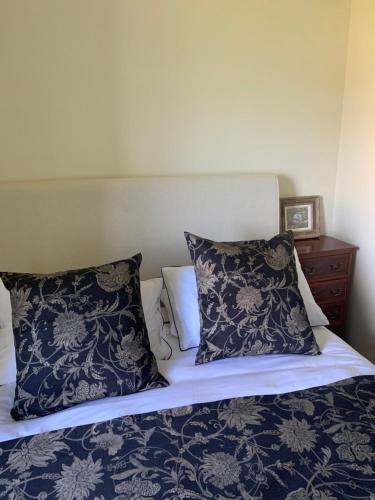 a bed with blue and white sheets and pillows at Tower View Apartment in Carrick