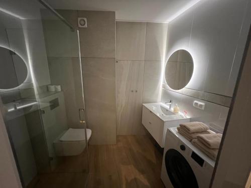 a bathroom with a toilet and a sink and a mirror at Apartamenty Novela Centrum in Słupsk