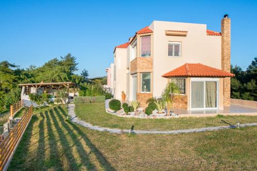a house with a large yard in front of it at Natura House in Ialyssos