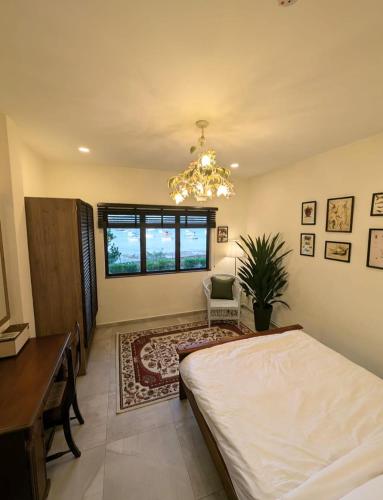 a bedroom with a bed and a desk and a chandelier at House of Melissa Boutique Farmstay in Singapore