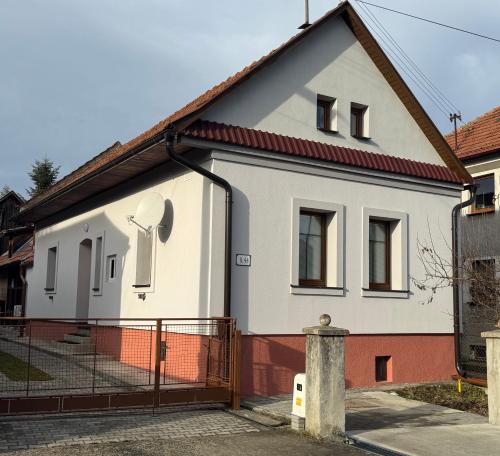 a white house with a fence in front of it at Chalupa DEMÄNOVÁ in Liptovský Mikuláš
