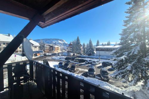 un groupe de voitures garées dans un parking dans la neige dans l'établissement Appartement cosy au cœur de La Féclaz, à La Féclaz