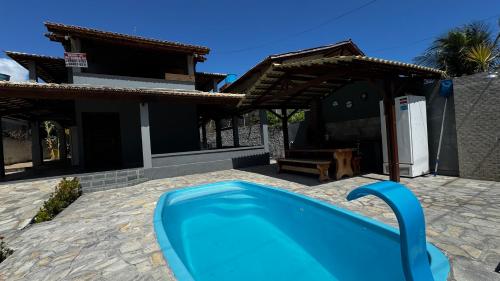 ein blauer Pool vor einem Haus in der Unterkunft Casa Praia de Tabatinga 2 a 70m do Mar in Conde