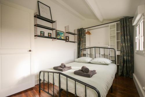 ein Schlafzimmer mit einem Bett mit Handtüchern darauf in der Unterkunft La Villa Seventies - Parking gratuit in Angoulême