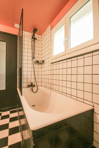 une salle de bain avec une baignoire et une fenêtre dans l'établissement La Villa Seventies - Parking gratuit, à Angoulême