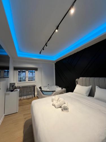 Un dormitorio con una cama y una bañera en una habitación. en Platinum Jacuzzi Tsakalof 17 by Zeussuites, en Atenas