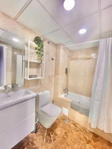 a bathroom with a toilet and a sink and a tub at Apartamento Narváez- Altos Del Tomillar in Torre del Mar